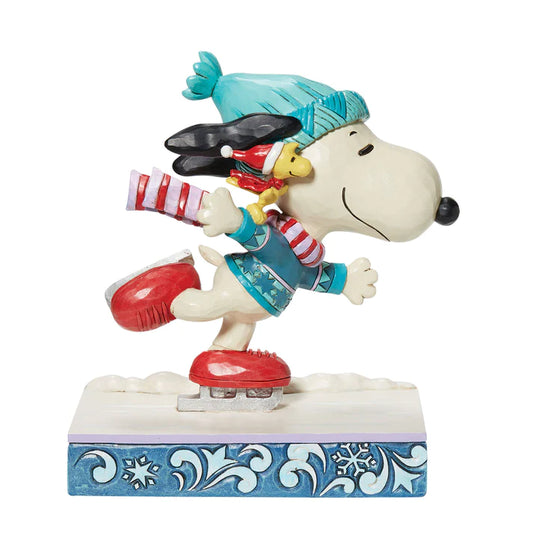 A figure of Snoopy in winter clothes ice skating with Woodstock wearing winter clothes on his shoulder.