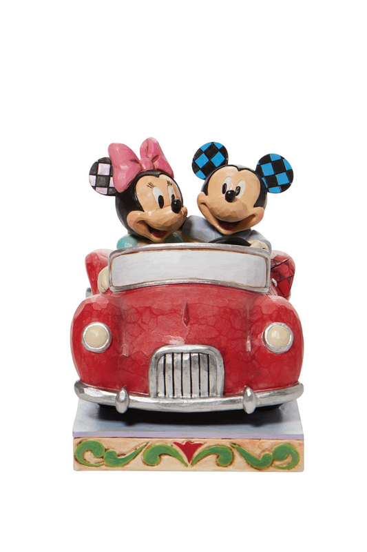 A figure of Mickey and Minnie mouse riding in a red car.