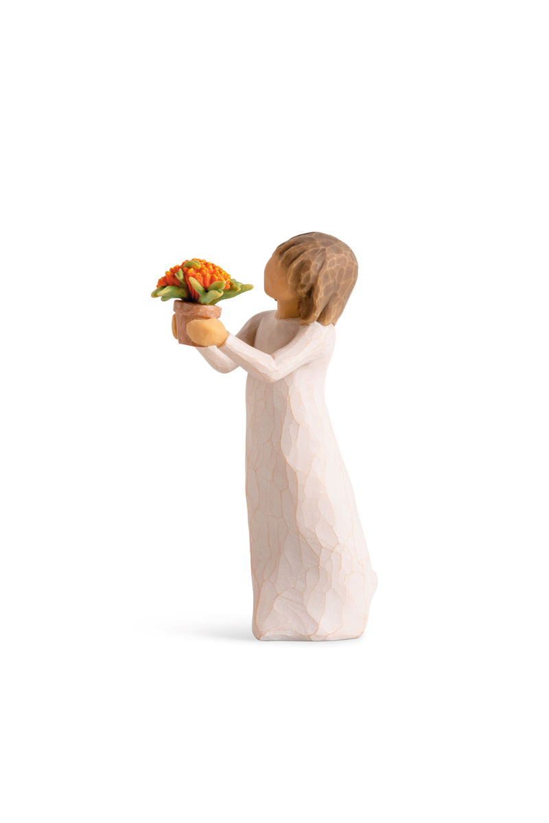 Willowtree figure of a girl in white with brown hair holding a flower pot containing an orange flower.