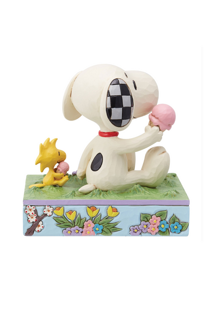Spring themed figuring of Snoopy and Woodstock siting on the grass eating ice cream. The base of the figurine is sky blue with floral embellishments. 