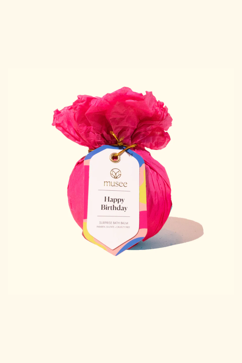 Musee bath bomb wrapped in hot pink tissue paper. 