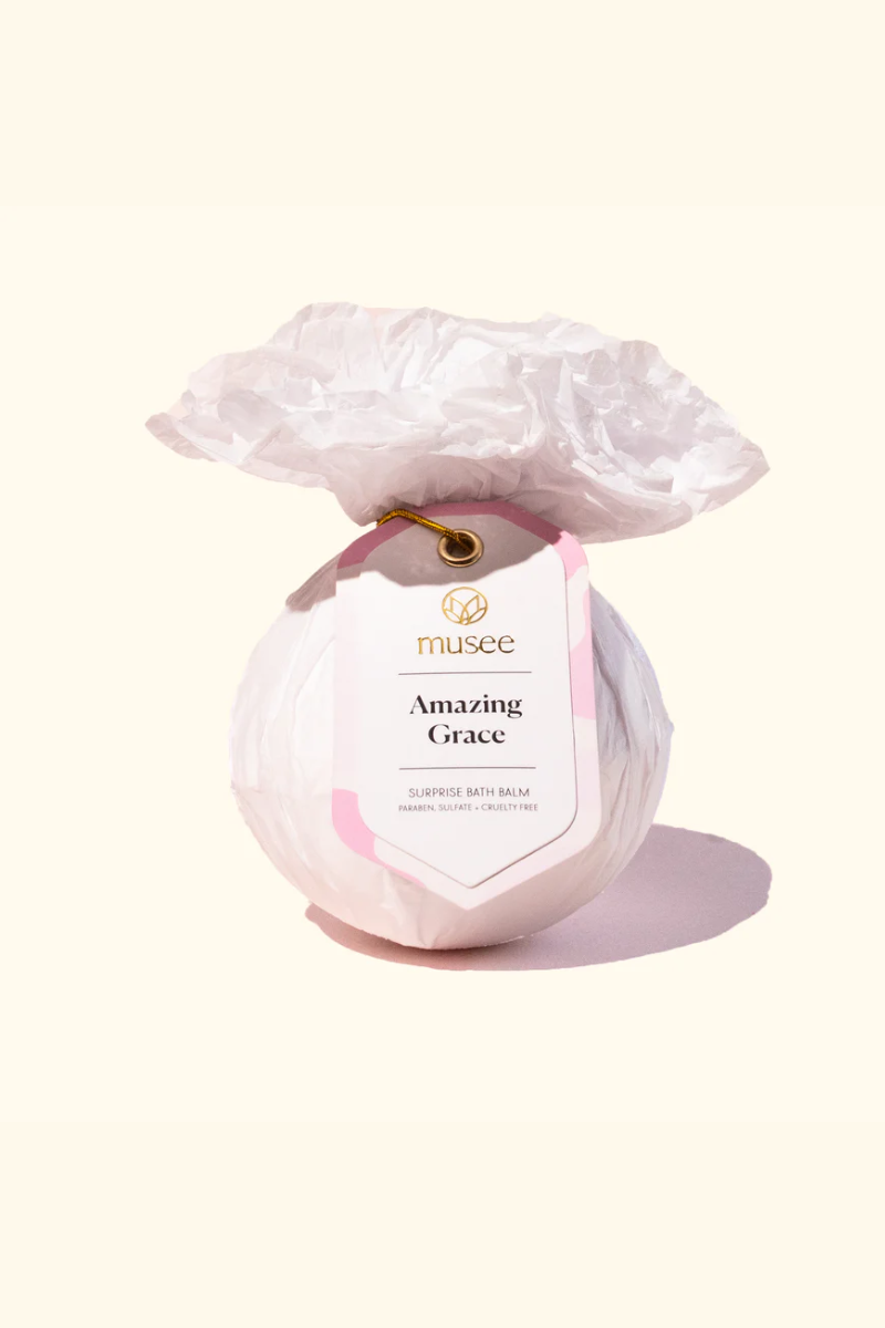 Musee bath bomb wrapped in light pink tissue paper. 