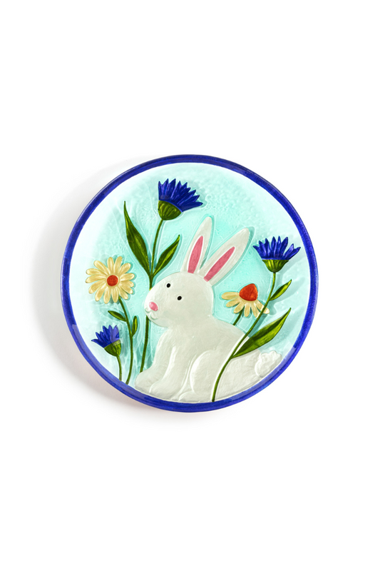 Decorative plate depicting a white rabbit among flowers on a sky blue background with a dark blue border.