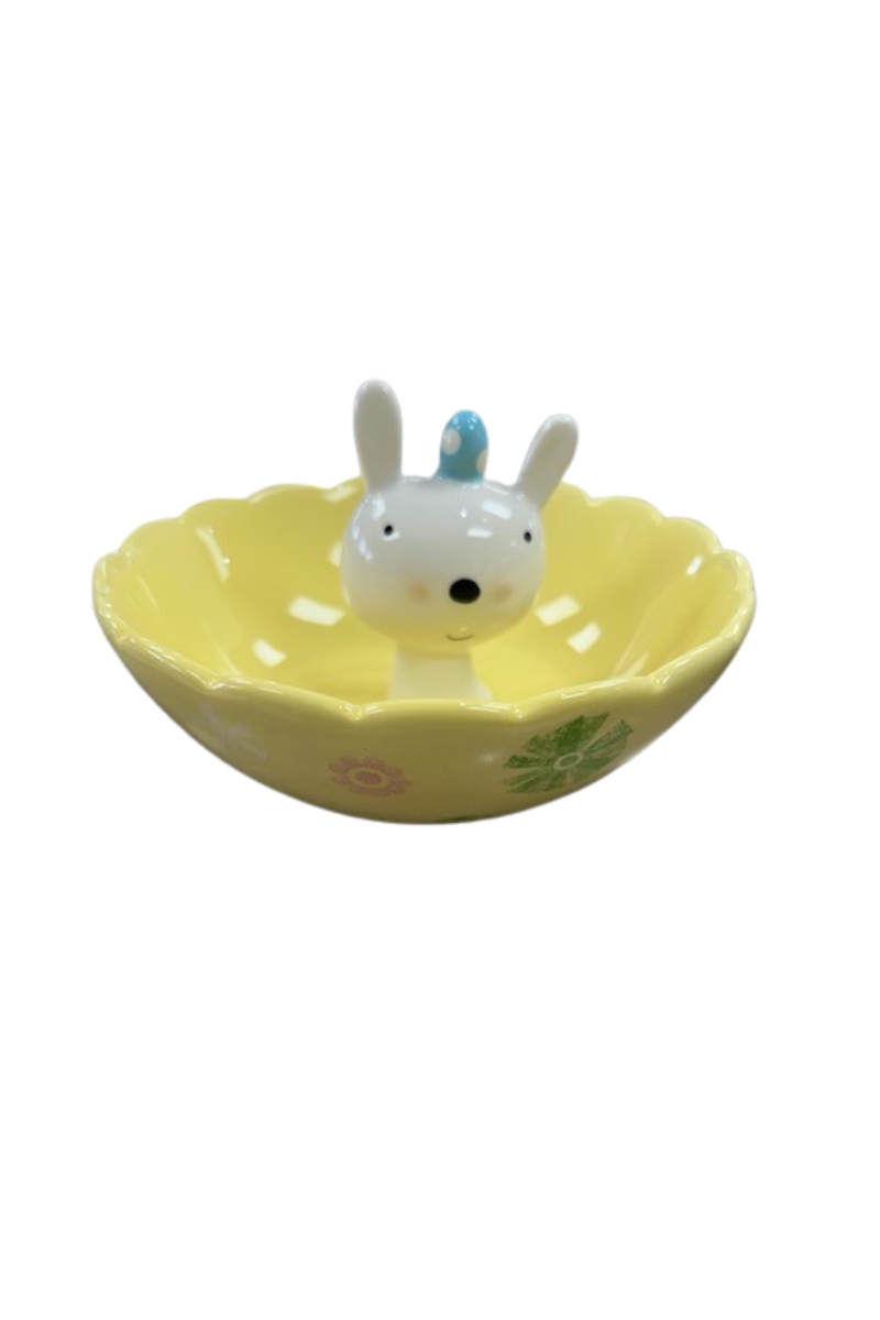 Yellow jewelry dish with Easter designs and a bunny head coming up out of the center with a blue Easter egg on its head.