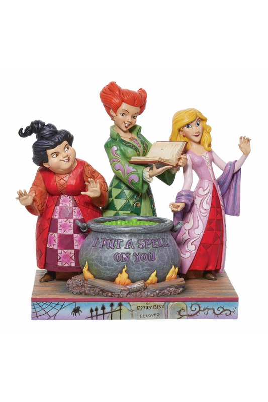 Figurine of the three witches from Hocus Pocus standing around a cauldron.