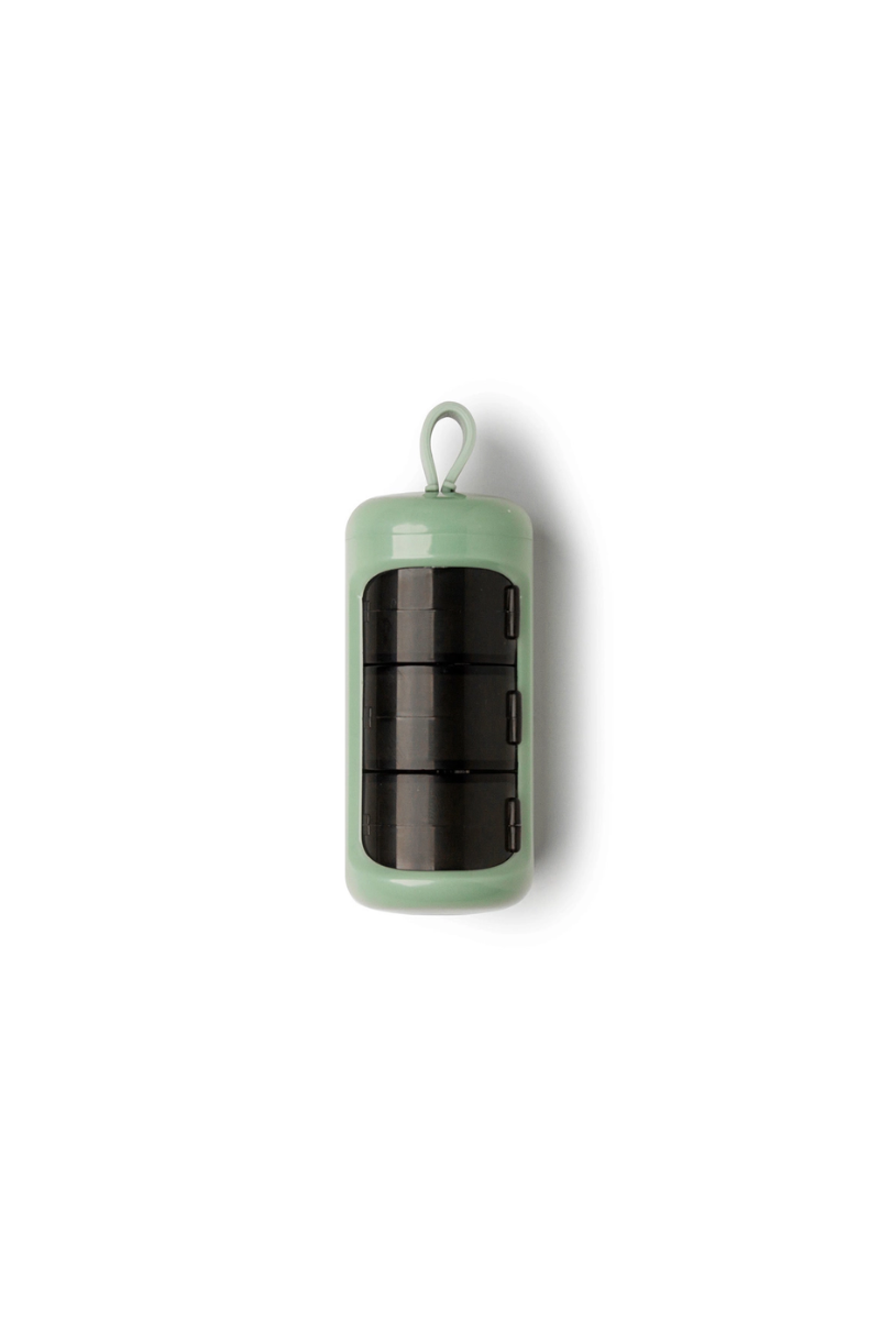 A green cylindrical pill case.