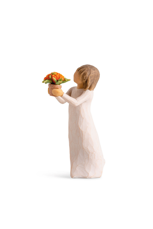 Willowtree figure of a girl in white with brown hair holding a flower pot containing an orange flower. 