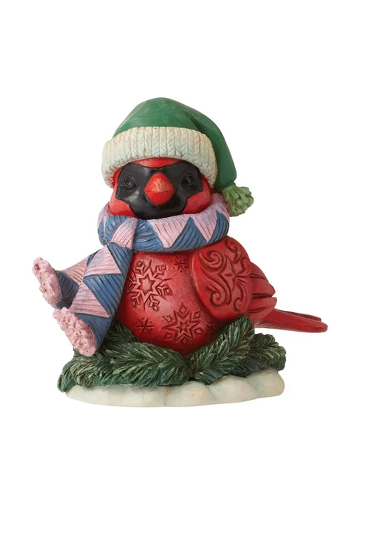 Christmas figurine of a red cardinal embellished with winter carvings wearing a blue and pink scarf and a green hat.